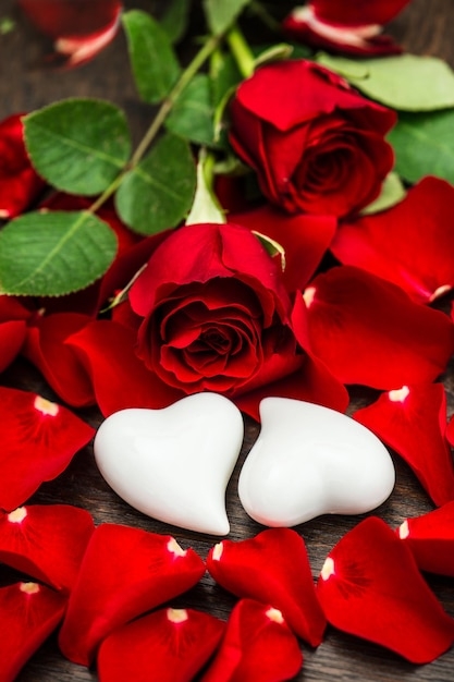 rote-rosen-und-zwei-weisse-herzen-valentinstag-oder-hochzeitskartenkonzept_154730-3233